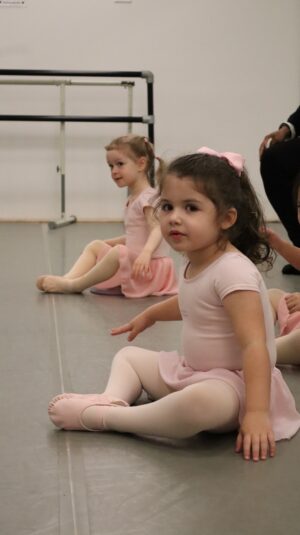 Two young girls sitting in ballet class