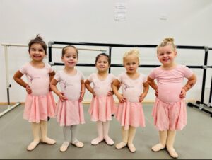 Five young girls in pink ballet outfits